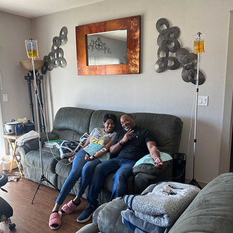 A couple relaxing on their couch at home during a mobile IV visit